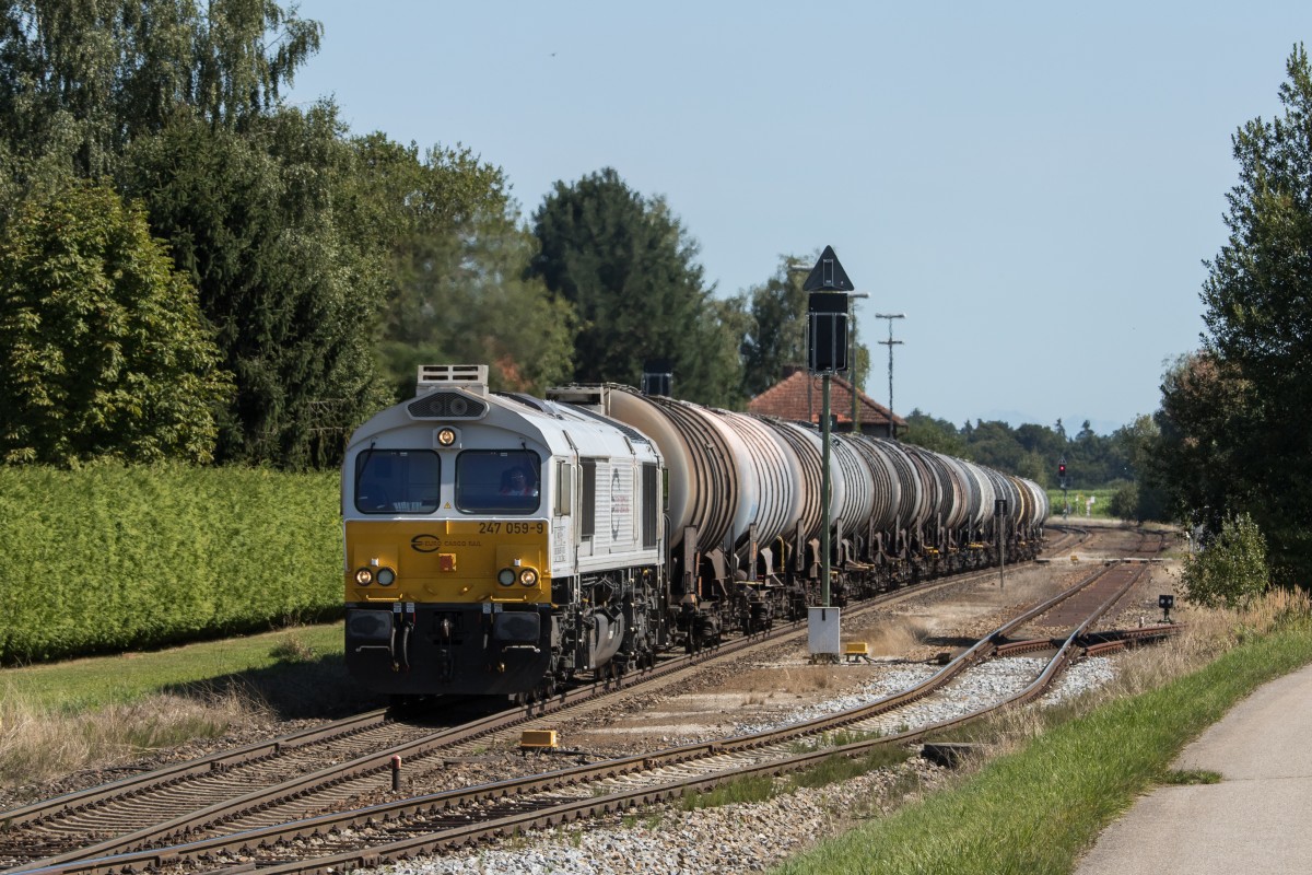 247 059-9 durchfhrt mit einem Kesselwagenzug aus Burghausen kommend am 26. August 2015 den Bahnhof von Pirach.