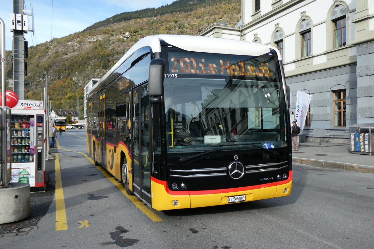 (281'696) - PostAuto Wallis - VS 565'809/PID 11'975 - eMercedes am 21. Oktober 2025 beim Bahnhof Brig