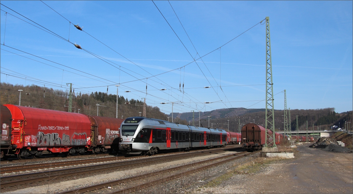 Abellio ET 232108 mit RE16 nach Siegen bahnt sich den Weg durch die Coilwagen am 20.02.21 in der Bahnhofseinfahrt von Finnentrop