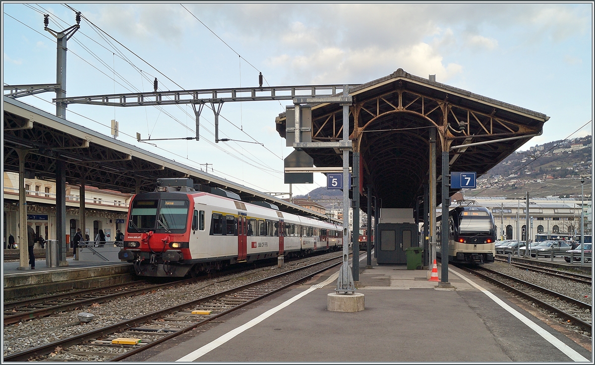 An den zum Teil neu renovierten Bahnsteigüberdachungen zeigen sich der SBB Regionalzug nach Puidoux und der CEV MVR Regionalzug nach Blonay. 

19.Februar 2019