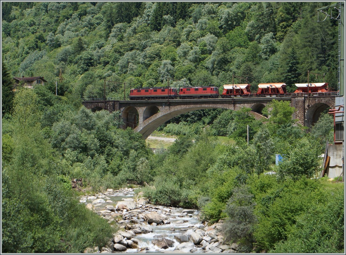Auf der Gotthard Südrampe kurz nach Faido ziehen eine Re 10/10 einen Kieswagenzug bergwärst. Bei genauerem Hinschauen, bemerkt man den zweiteiligen Kasten der SBB Re 6/6. 

23. Juni 2015