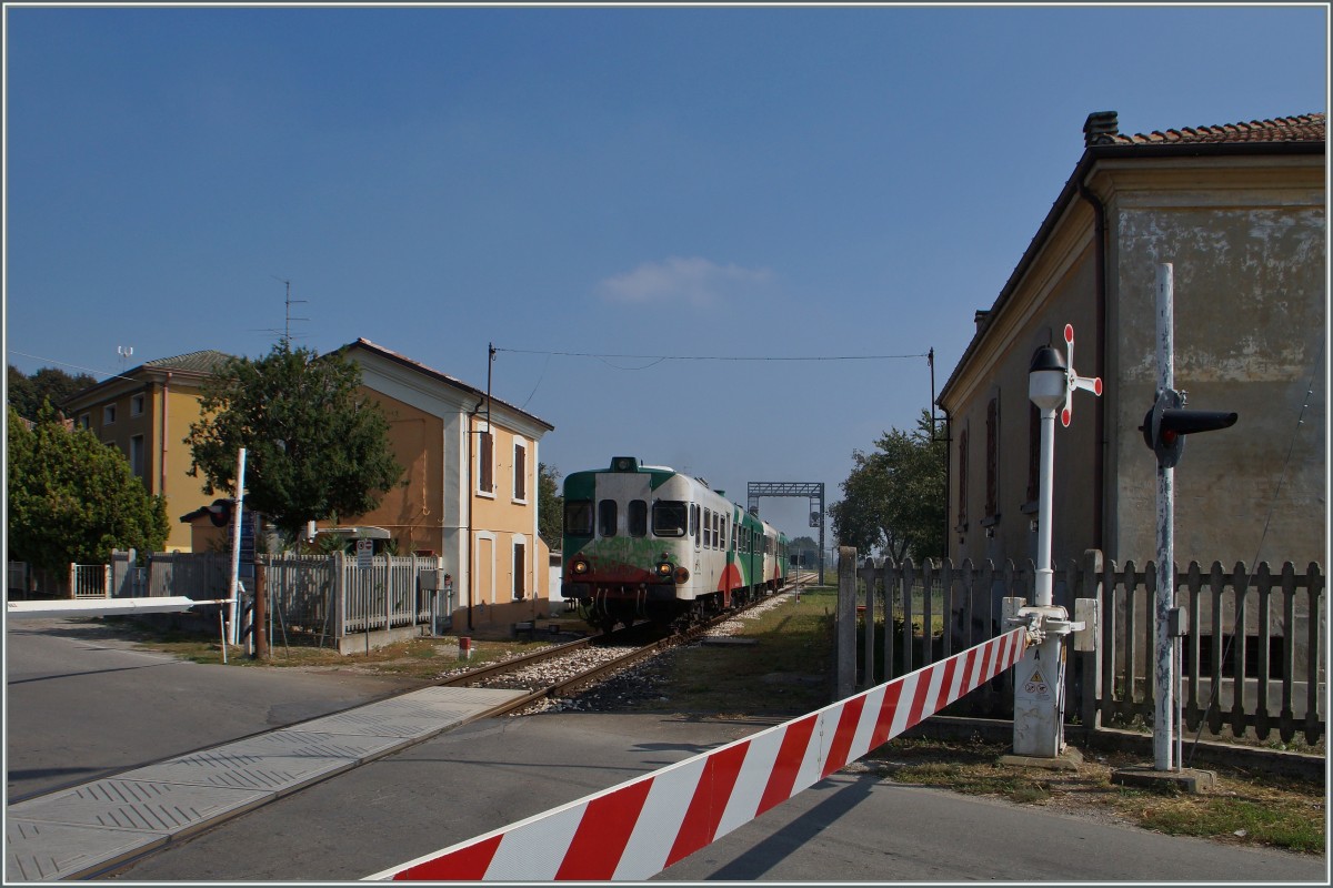 Bahnübergang  II: Ein FER Triebzug der Reihe Aln 668 verlässt Brescello. 
22. Sept. 2014