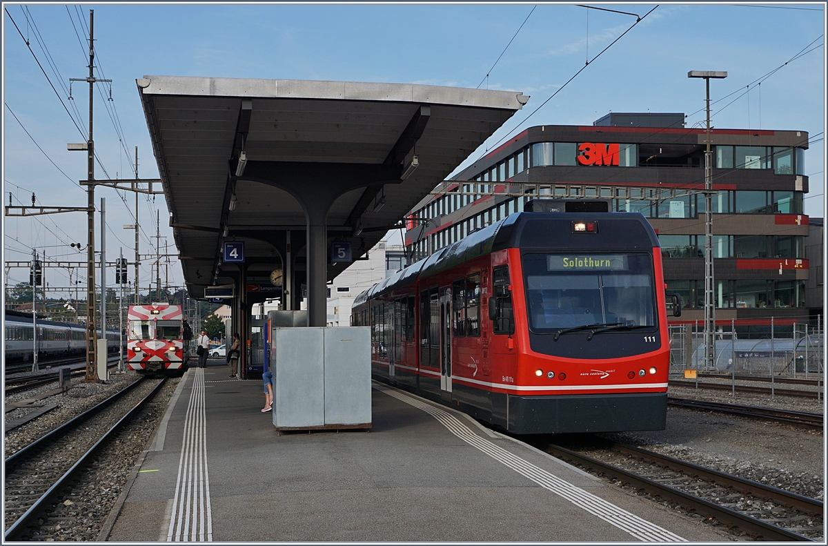 Der asm Be 4/8 111  Jupiter  wartet in Langenthal auf die Abfahrt nach Solothurn. 
Im Hintergrund wird der Be 4/4 114 mit Bt (1)12 (ex FW) als Regionalzug nach St.Urban bereitgestellt.

10. August. 2020