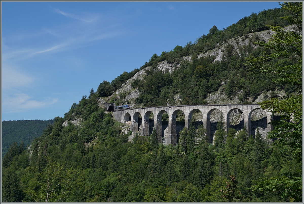 Der SNCF X 73657 hat den 69 Meter langen Tunnel des Crottes verlassen und fährt nun über den aus zehn Bogen und in einer langen Kurve liegenden 165 Meter langen Viaduc des Crottes. Der Dieseltriebwagen ist als TER 895511 von Dole nach St-Claude unterwegs. 10. August 2021