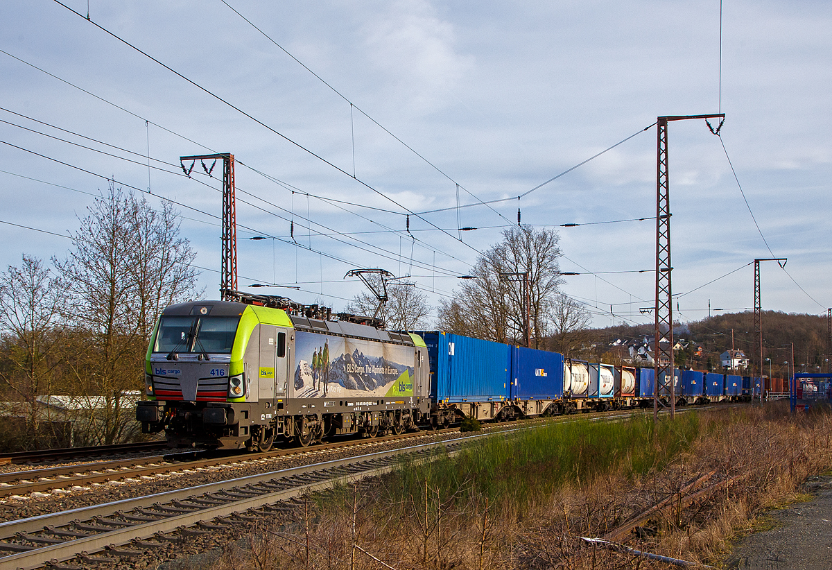 Die BLS Cargo 416  – Re 475 416-4 (91 85 4475 416-4 CH-BLSC) fährt am 12.02.2022 mit einem Containerzug durch Rudersdorf (Kr. Siegen) über die Dillstrecke (KBS 445) in nördlicher Richtung.

Die Siemens Vectron MS wurden 2020 von Siemens unter der Fabriknummer 22751 gebaut, sie hat die Zulassungen für CH/ D/ A/ I / NL/(B) und kann so vom Mittelmeer bis an die Nordsee ohne Lokwechsel durchfahren. Sie haben eine Höchstgeschwindigkeit von 200 km/h und eine Leistung von 6.400 kW.

Nach Abschluss der Lieferungen der 2. Serie hat die BLS Cargo dann insgesamt 40 Loks der Baureihe Re 475 (Siemens Vectron MS). Der kleine Unterschied zwischen der beiden Serien ist nur das die Lok der 2. Serie auch durch Belgien fahren sollen, nach meiner Sichtung ist aber noch nicht die Zulassung für Belgien erteilt, da B noch durchgestrichen ist.
