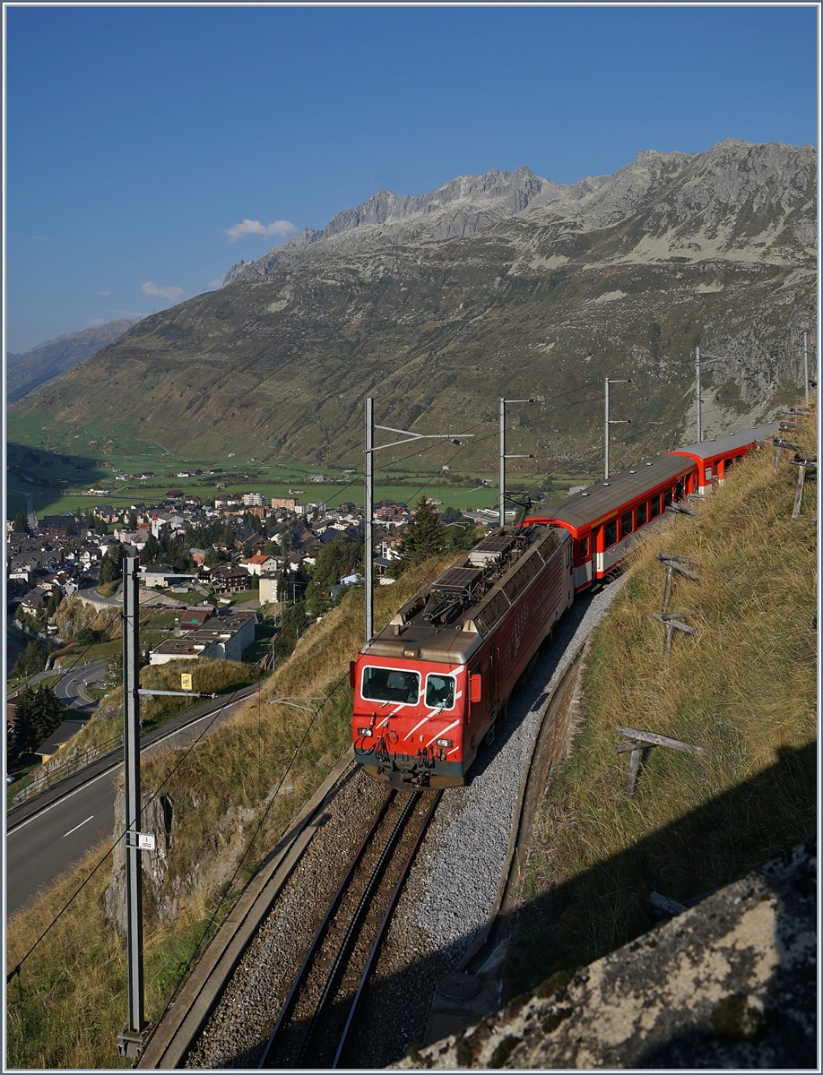 Die MGB HGe 4/4 II 108 ist mit ihrem Regionalzug 819 von Disentis kommend schon bald am Ziel ihrer Fahrt nach Andermatt, welches bereits zu erkennen ist. 

17. Sept. 2020