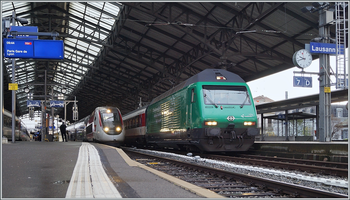 Die Re 460 007  125 Jahre Vaudoise Versicherungen  mit einem IR 90 in Lausanne, im Hintergrund steht ein TGV LYRIA nach Paris Gare de Lyon. 

30. Dez. 2020