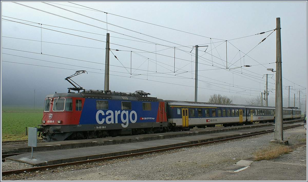 Die SBB Re 420 186-9 mit einem Regionalzug nach Buttes beim Halt in Noiraigue. 

19. Nov. 2009