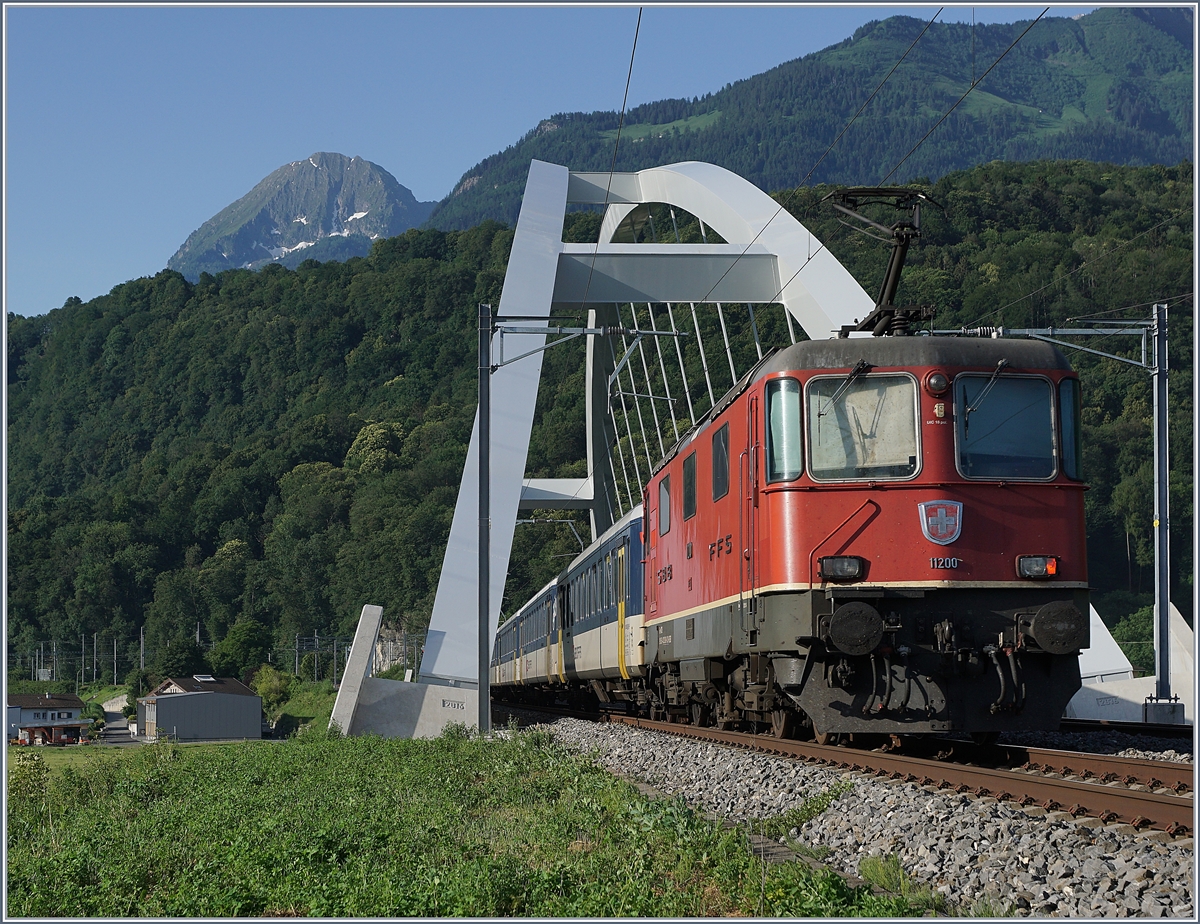 Die SBBB Re 4/4 II 11200 mit einer weiteren an der Zugsspitze sind sind mit einen  Dispozug  bei der neuen Rhone-Brücke bei Massogex auf der Fahrt in Richtung Brig. 

25. Juni 2019