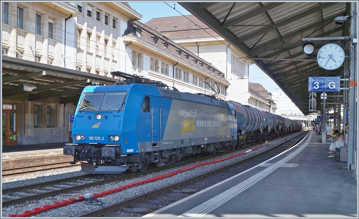 Eine E-Lok der Baureihe 185 ist seit etlichen Jahren eigentlich etwas alltägliches: In Lausanne hingegen bekommt man seit dem Ende der RTS diese Lokgattung eher selten zu sehen, so dass es sich selbst bei ungünstigem Licht anbot, die für die WRS fahrende 185 535 (UIC 91 80 6185 535-2 D-ATLU) zu fotografieren, die mit einem Kesselwagenblockzug auf Gleis 2 auf die Weiterfahrt wartet. 27. Juni 2020