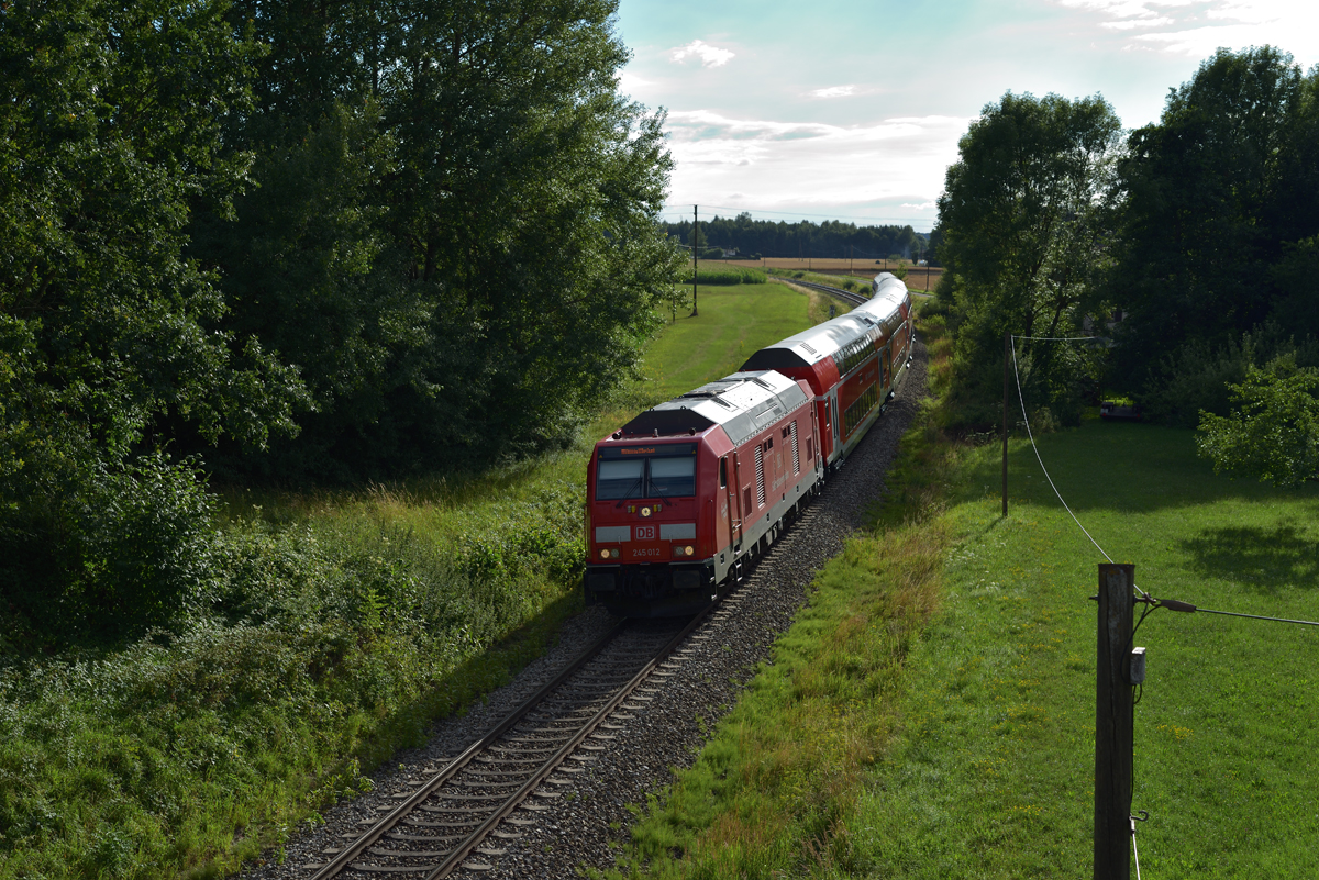 Im Gegenlicht wurde 245 012-0 mit ihrem Dosto-Zug bei Englpolding am Abend des 15.07.17 bildlich festgehalten. Ihr Weg führte sie - wie so oft - von München Hbf nach Mühldorf.