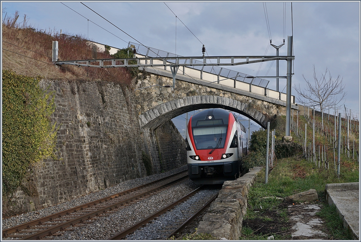 In Cully steht eine der wenigen  alten  Brücken über die Simplon Linie, welche auch Doppelstockzügen genügend Platz bietet und nicht ersetzt werden musste. Das Bild zeigt den SBB RABe 511 117 als RE 3122 von Vevey nach Genève.
30. Jan. 2018
