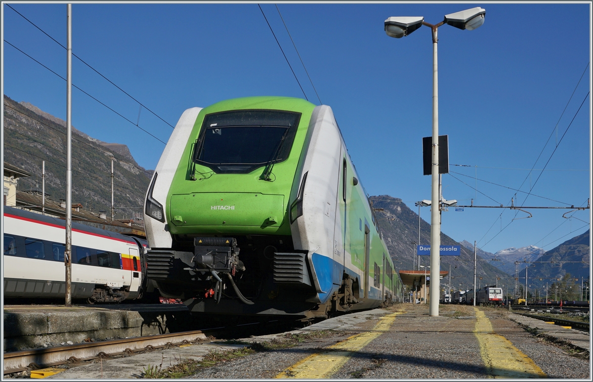 In Domodossola wartet der Trenord ETR 421 017 (94 83 4421 817-7 I-TN) auf seinen nächsten Einsatz; er wird als Trenord Regio 2431 um 14:56 nach Milano abfahren. Der Standort des Zugs und der unpassend kurze Bahnsteig erlauben im Rahmen der Gelben Linien nur eine Bild aus dieser Perspektive. 

22. Okt. 2021