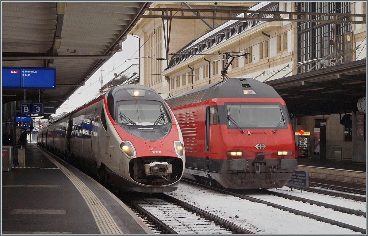 Links im Bild der nur auf dem Abschnitt Lausanne - Brig verkehrende EC 39 in Form eines SBB ETR 610 (Pinocchio) kurz vor der Abfahrt in Lausanne, rechts im die Bild die Re 460 070-6 mit der verdeckten Re 460 045-8, die auch auf dem Weg nach Brig sind.

17. Januar 2021