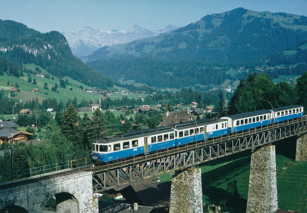 MOB: Stilreiner blauer Regionalzug mit dem ABDe 8/8 4002  VAUD  bei Passieren des Viadukts bei Gstaad im Juli 1991.
Foto: Walter Ruetsch