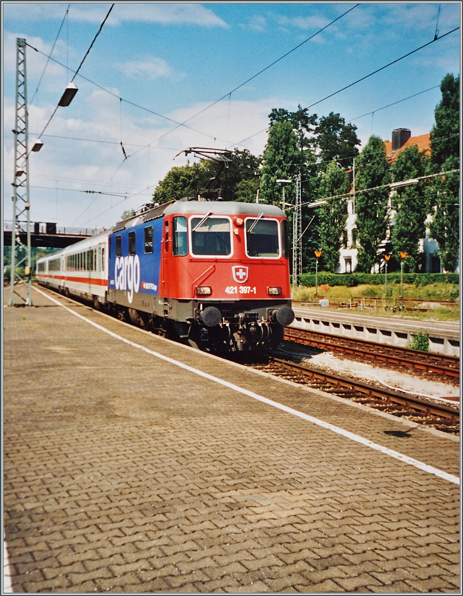 Nach dem Wegfall der DB ICE -TD 605 verkehrt das Zugspaar EC 195/196 mit DB Wagenmaterial. Das Bild zeigt die SBB Cargo Re 421 379-1 bei der Ankunft in Lindau Hbf. 

Analogbild vom 27. Juli 2004