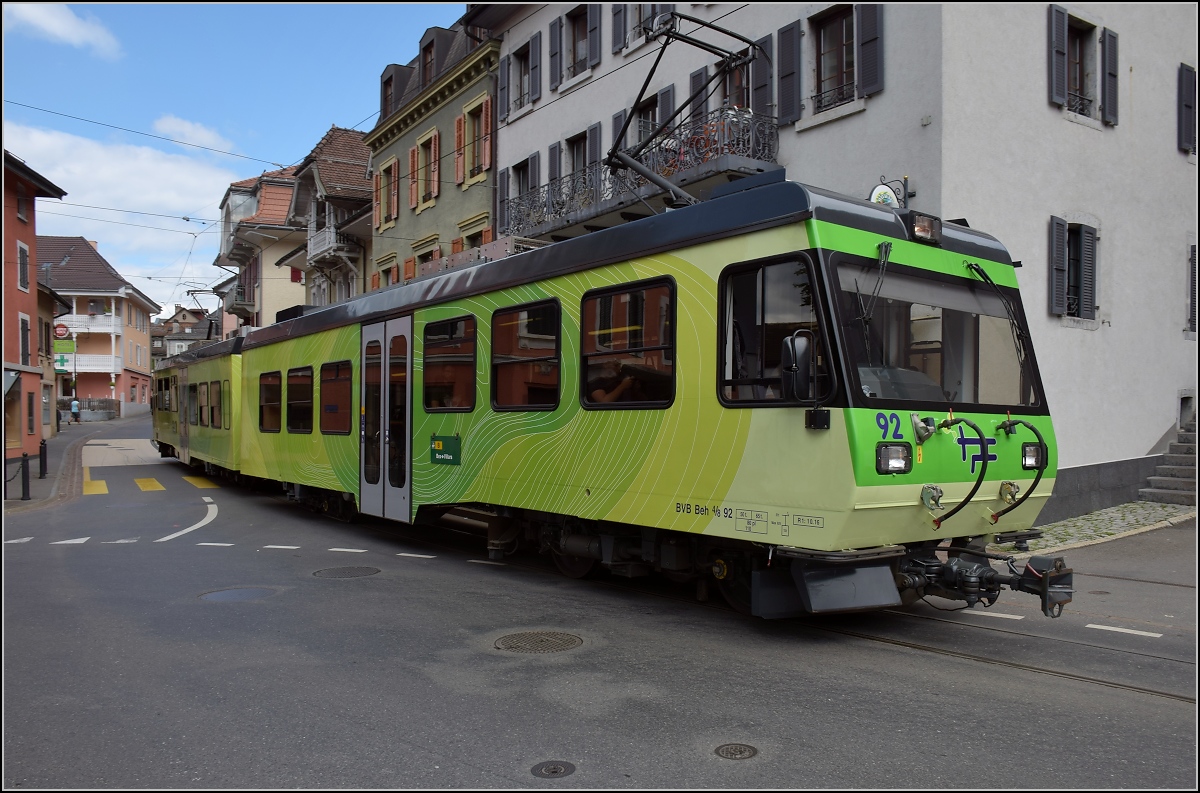 Ortsdurchfahrt in Bex. Linksabbieger im Gegenverkehr, der TPC-Triebwagen 92 nutzt die falsche Stra�enseite. Juli 2017.