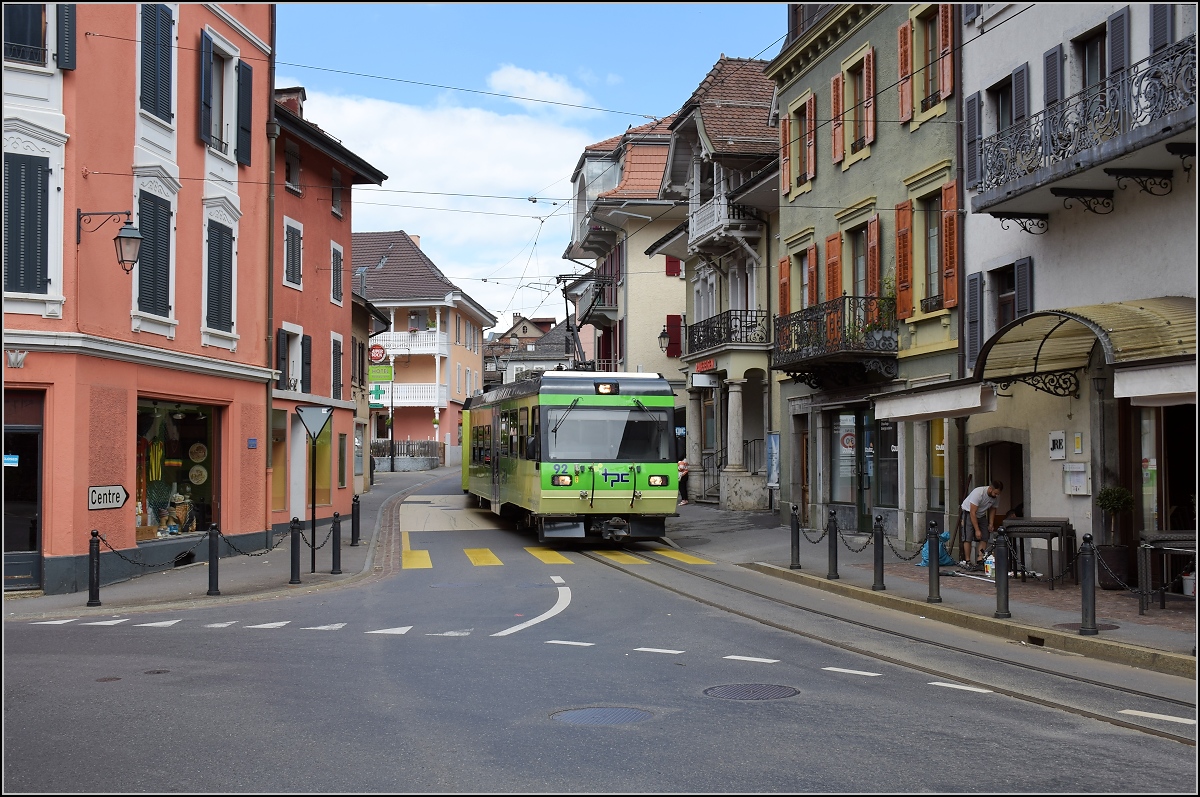 Ortsdurchfahrt in Bex. Linksabbieger im Gegenverkehr, der TPC-Triebwagen 92 nutzt die falsche Stra�enseite. Juli 2017.