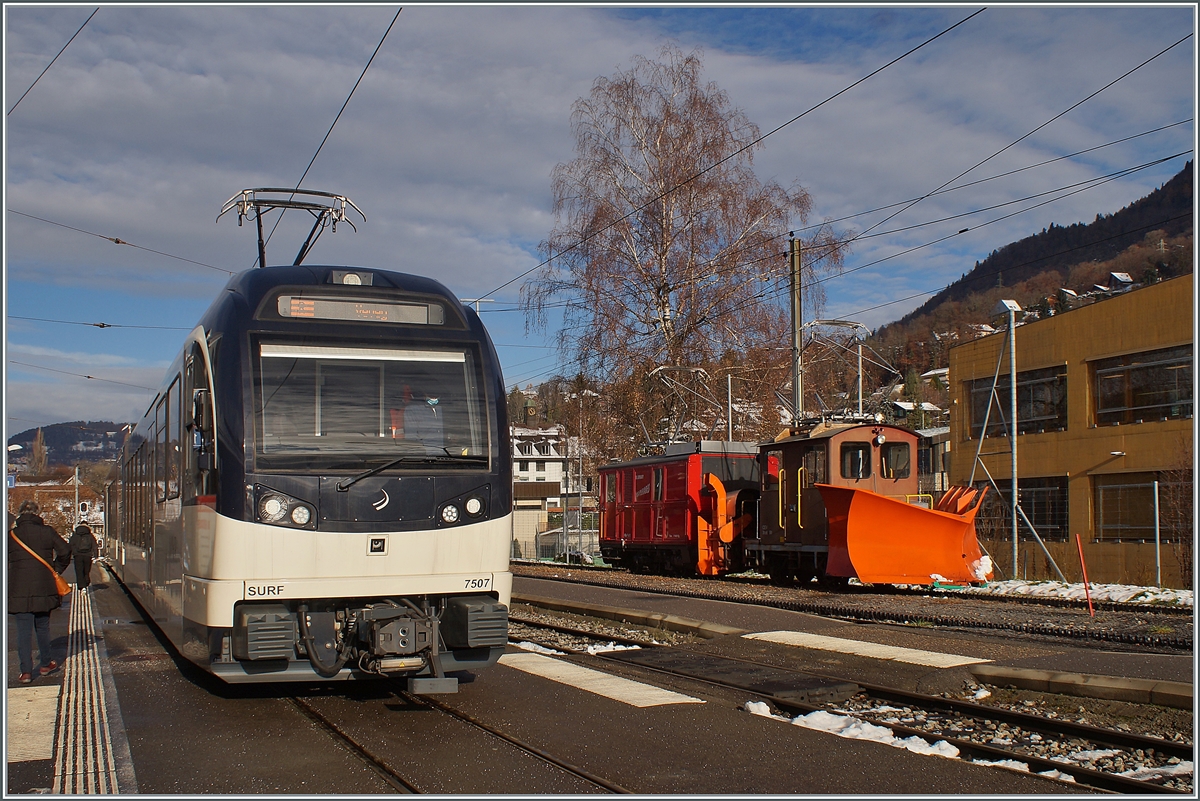 Während der aus Vevey in Blonay angekommen CEV MVR ABeh 2/6 7507 für die baldige Rückfahrt nach Vevey auf Gleis 1 wendet, steht auf Gleis 4 der CEV Xrot 91 und die 1911 gebaute CEV HGe 2/2 N° 1.

1. Dezember 2021