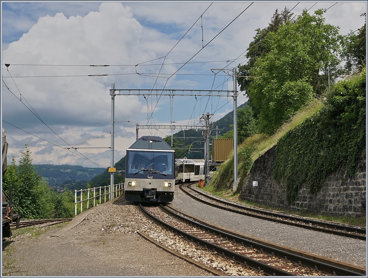 Zugkreuzung des MOB PE 2115 Zweisimmen - Montreux und des Gegenzugs PE 2122 in Chamby: Der MOB Panoramic Express PE 2115 mit dem seit kurzem neu hergerichteten Steuerwagen Ast 117 erreicht Chamby. 

13. Juni 2020