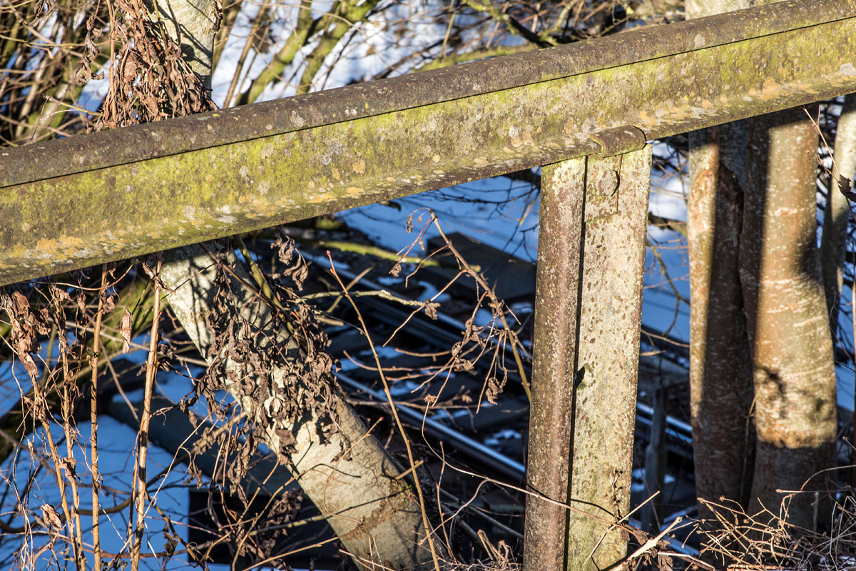 Zwei Schienengenerationen treffen an einer Bahnbrücke in Thann-Matzbach aufeinander.

Während die Schienen der KBS 940 an ihrer Oberfläche vor Glanz nur so strotzen, wurde einem alten  Veteran  ein weiteres Leben als Geländer im Bereich des Brückenzuganges geschenkt. Und auch das gewiß seit vielen Jahren.
