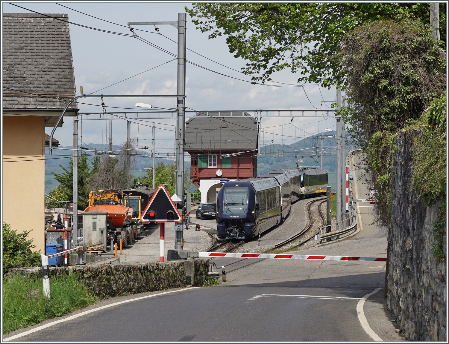 Blick auf den Bahnhof von Chamby mit dem dort auf den Gegenzug wartenden BLS MOB GoldenPass Express nach Montreux.

6. Mai 2023