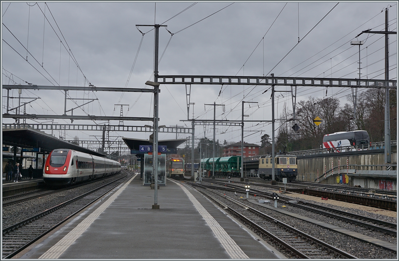 Blick auf den Bahnhof von Morges mit einen SBB RABe 500 ICN nach Rorschach, einem BAM MBC Regionalzug nach Biere und der IRSI Re 4/4 II 11387 (Re 421 387-2) die z.Z. im Dienste der BAM MBC stehet.

22. Februar 2024