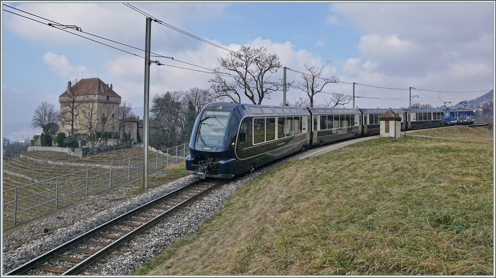 Der GoldenPass Express 4065 von Interlaken Ost nach Montreux fährt bei der Haltstelle Châtelard durch, links im Bild das namensgebende Schloss. 

8. Feb., 2023