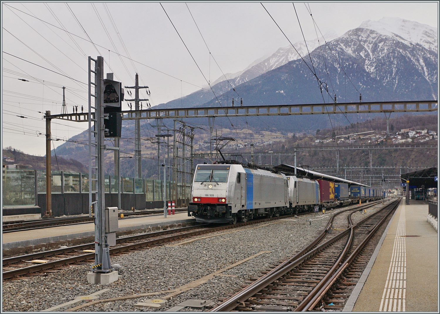 Die 186 509 und eine weitere Railpool Maschine sind mit einem Güterzug in Brig auf dem Weg in Richtung Norden. 

2. Feb. 2024