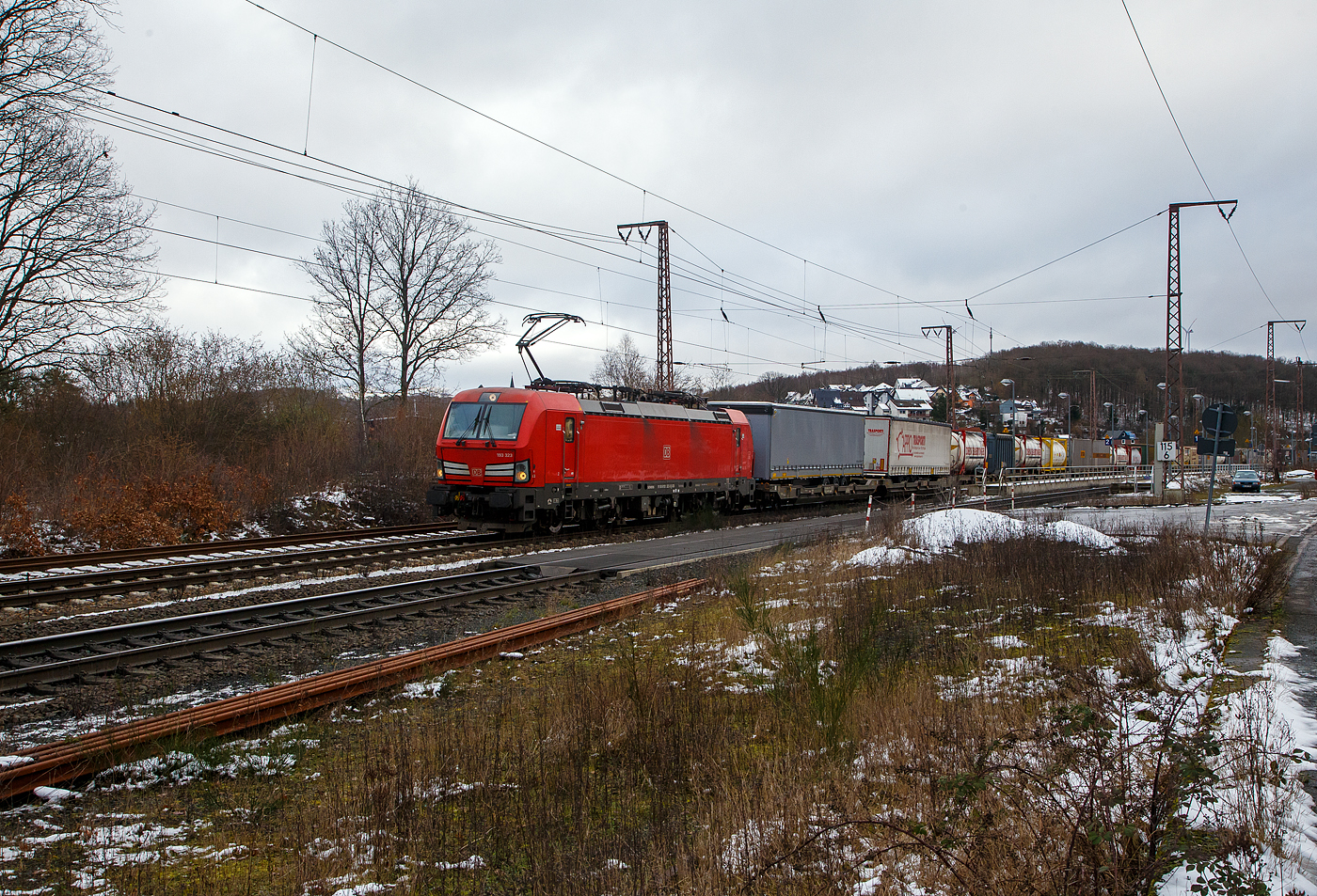 Die 193 323-3 (91 80 6193 323-3 D-DB) der DB Cargo AG fährt am 27.01.2023 mit einem „HUPAC“ KLV-Zug durch Rudersdorf (Kr. Siegen) in Richtung Siegen. Hier befährt der Zug die Dillstrecke (KBS 445) von dieser geht es bei Siegen-Ost auf die Siegstrecke (KBS 460) in Richtung Köln. Weil die Ruhr-Sieg-Strecke (KBS 440) nicht das KV-Profil P/C 400 aufweist, sind solche Züge dort nur bis Kreuztal zum Südwestfalen Container-Terminal möglich.

Die Siemens Vectron MS (200 km/h - 6.4 MW) wurden 2018 von Siemens unter der Fabriknummer 22448 und gebaut, sie hat die Zulassungen für Deutschland, Österreich, Schweiz, Italien und die Niederlande (D/A/CH/I/NL).