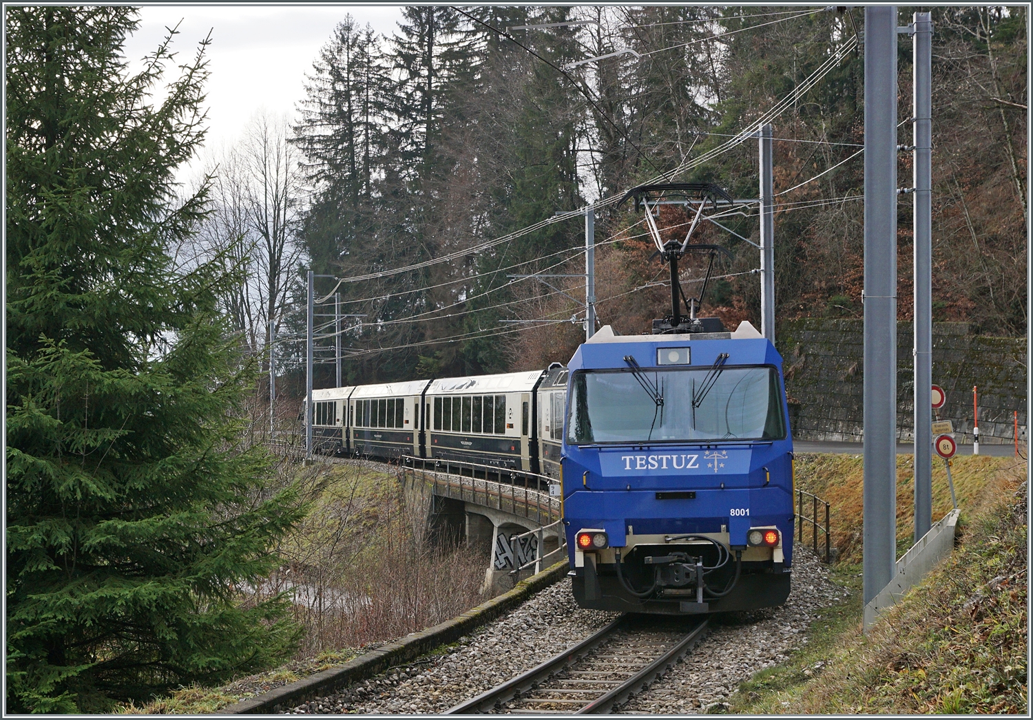Die MOB Ge 4/4 8001 ist als Schublok mit dem GoldenPass Express 4065 von Interlaken nach Montreux unterwegs. Die Ge 4/4 8001 hat den Zug in Zweisimmen übernommen und rollt nun kurz nach der 93 Meter langen Pont Gardiol, welche den Bois des Chenaux überbrückt, ihrem Ziel Montreux entgegen. 

4. Januar 2023