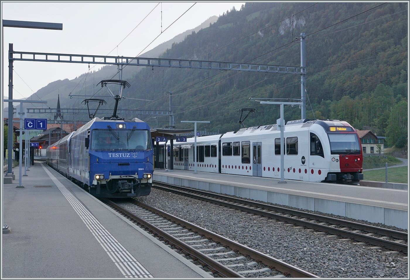 Die MOB Ge 4/4 8001 ist mit dem GoldenPass Express GPX 4064 in Montbovon auf dem Weg nach  Interlaken Ost. Rechts im Bild ein TPF SURF nach Palézieux. 

24. Aug. 2023