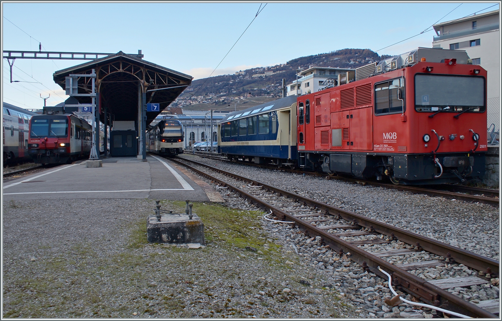 Die MOB HGem 2/2 2501 (ex MVR HGem 2/2 2501) und der vor einigen Jahren zum Jubiläum  40 Jahre GoldenPass Express  vor einigen Jahren in den farblichen Ursprungszustand zurückversetze MOB As 110 zeigen sich in Vevey. Wo der Rest des Tags zuvor in Blonay fotografieren Zuges abgeblieben ist, konnte ich leider nicht feststellen.

In der linken Bildhälfte zeigt sich der CEV ABeh 2/6 nach Blonay und ein SBB Domino nach Chexbres. 
 
4. Februar 2023