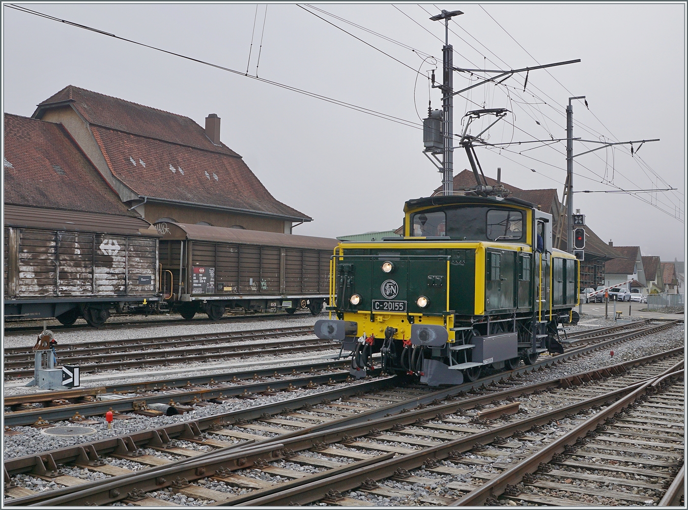 Die SNCF C 20155 UIC N° 97 85 1 932-0 (ex SBB Ee 3/3 II 16515, ex SNCF C 20155) des Verein  Team C-20155  erreicht Balsthal von der Klus kommend. Das Dreispitzen Signal signalisiert, dass es sich hier um eine Zugfahrt handelt. Die als Rangierlok konzipierte Zweistrom Ee 3/3 II wurde von der SNCF als Streckenlok für die Güterzüge zwischen Saint Louis und Muttenz in neun Exemplaren beschafft, da nach der Elektrifizierung der SNCF Strecke Mulhouse - Bâle SNCF die Beförderung der Güterzüge zu Reklamation der Anwohner führte. Eigentlich erstaunlich, galt doch Basel um 1960 als Hochburg des Dampfbetriebes in der Schweiz! Übrigens - Jahre später verhinderten ähnliche Reklamationen die durchgehende Bespannung der Linie 4 Fernzüge von Paris Est nach Basel mit den CC 72000 Diesellok; in Belfort oder Mulhouse mussten in den meisten Fällen die Lok gewechselt werden. Doch zurück zur die SNCF C 20155 UIC N° 97 85 1 932-0 (ex SBB Ee 3/3 II 16515, ex SNCF C 20155) des Verein  Team C-20155 . Eine Splittergattung einer SNCF Lok, die nach gut zehn Jahren zur SBB kam und dort gut vierzig Jahre im Rangierdienst stand, später vor der Verschrottung gerettet und in die ursprüngliche SNCF Version  zurück  restauriert mag erstaunen und schien nicht ganz unumstritten. Ich finde die Lösung aber sehr gut, so hebt sich die schöne Lok hervor. Zudem - die Lok mag von der SNCF im Streckendienst eingesetzt worden zu sein und lief im Grenzverkehr ja etwa zur Hälfte bei der SNCF und der SBB, betrachtet man jedoch die territoriale Grenze, so fuhren die SNCF C 20150 auf den insgesamt 15 Kilometer zwischen Saint Louis und Muttenz nur drei Kilometer in Frankreich. 8. November 2025