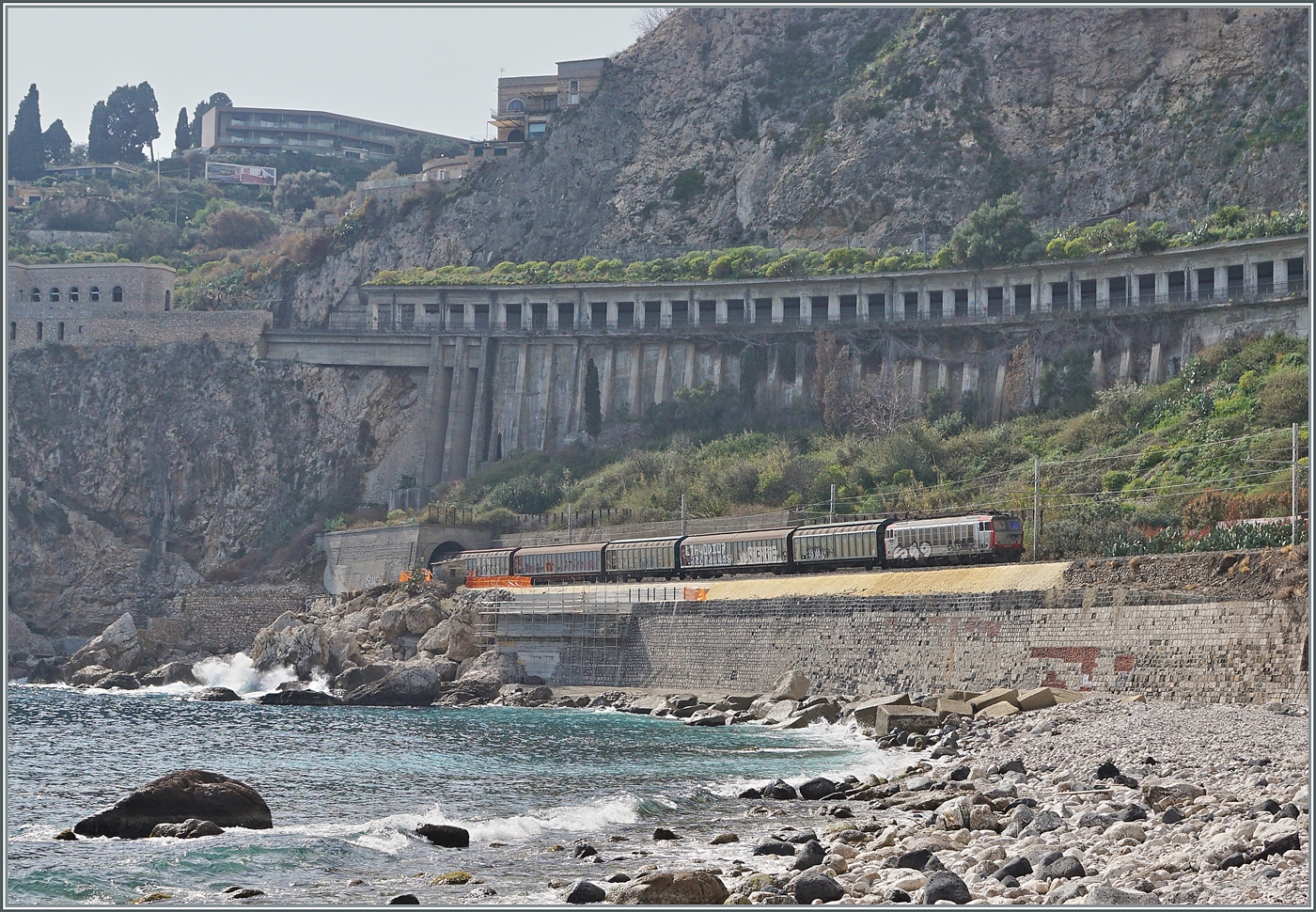 Eine Mercitalia E 652 ist mit einem G�terzug bei kr�ftigem Gegenlicht kurz nach Taormina Giardini auf dem Weg nach Messina.

8. M�rz 2026