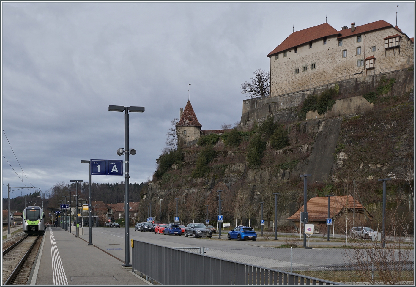 Hoch oben thront das Schloss von Laupen und unten im neune Bahnhof wartet der BLS RABe 528 104  MIKA  auf die Abfahrt in Richtung Bern. 

24. Jan. 2024   
