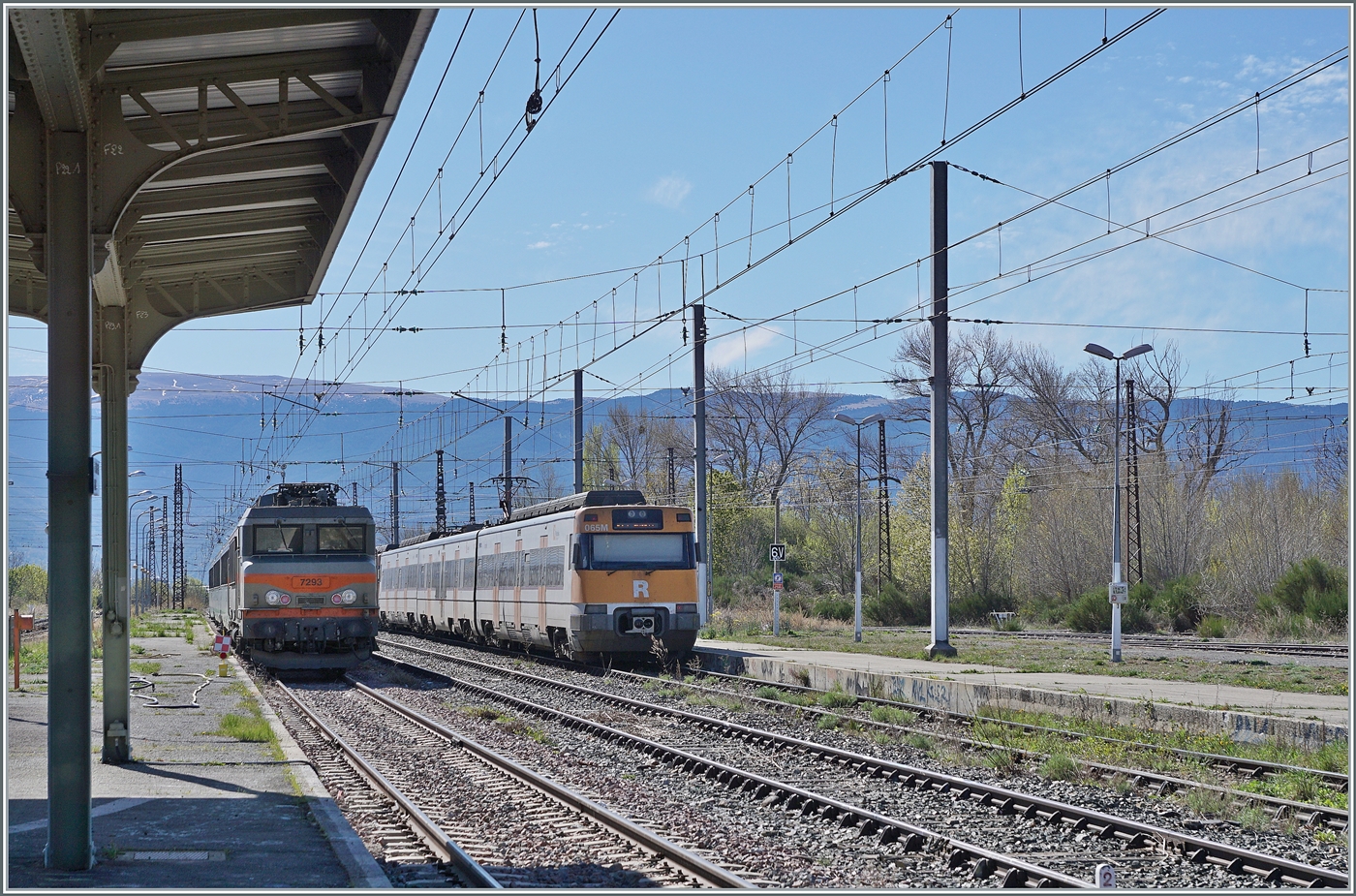 Im flächenmässig recht grossen Bahnhof von La Tour-de-Carole-Enveitg mit drei Spurweiten (Breitspur, Normalspur und Schmalspur) und recht wenig Verkehr verlassen der RENFE ETB 7 447 065-4 und ein weiterer als Regionalzug in Richtung Barcelona. Im Hintergrund ist die SNCF BB 7293 mit dem abgestellten Nachtschnellzug nach Paris zu sehen. 

19. April 2024 