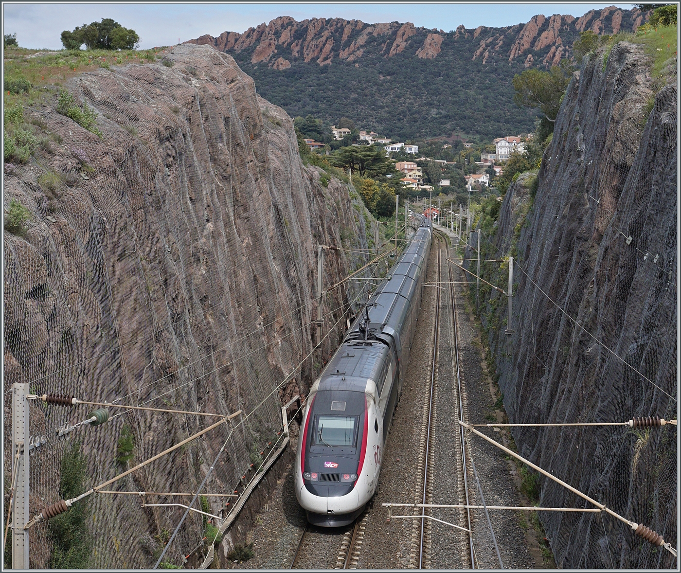 In einem felsigen Einschnitt kurz vor Agey sind zwei TGV auf dem Weg in Richtung Nice-Ville. 

24. März 2025