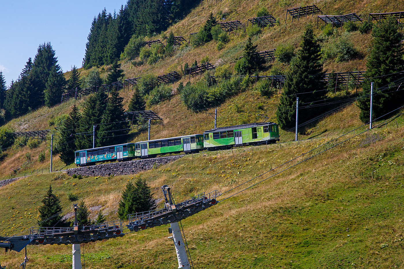 TPC 125 Jahre BVB! (Les TPC célèbrent les 125 ans du BVB!):
Der tpc BVB BDeh 4/4 – 81 „Gryon“ ein elektrischer Personentriebwagen mit Gepäckabteil für den gemischtem Adhäsions- und Zahnradbetrieb der Bex–Villars–Bretaye-Bahn, fährt am 10 September 2023 vom Bergbahnhof Col-de-Bretaye (1.808 m ü. M.) nun wieder hinab nach Villars-sur-Ollon. Vor dem Triebwagen sind die beiden Steuerwagen tpc BVB Bt 61(ex BVB B 53) und der Steuerwagen tpc BVB Bt 63.