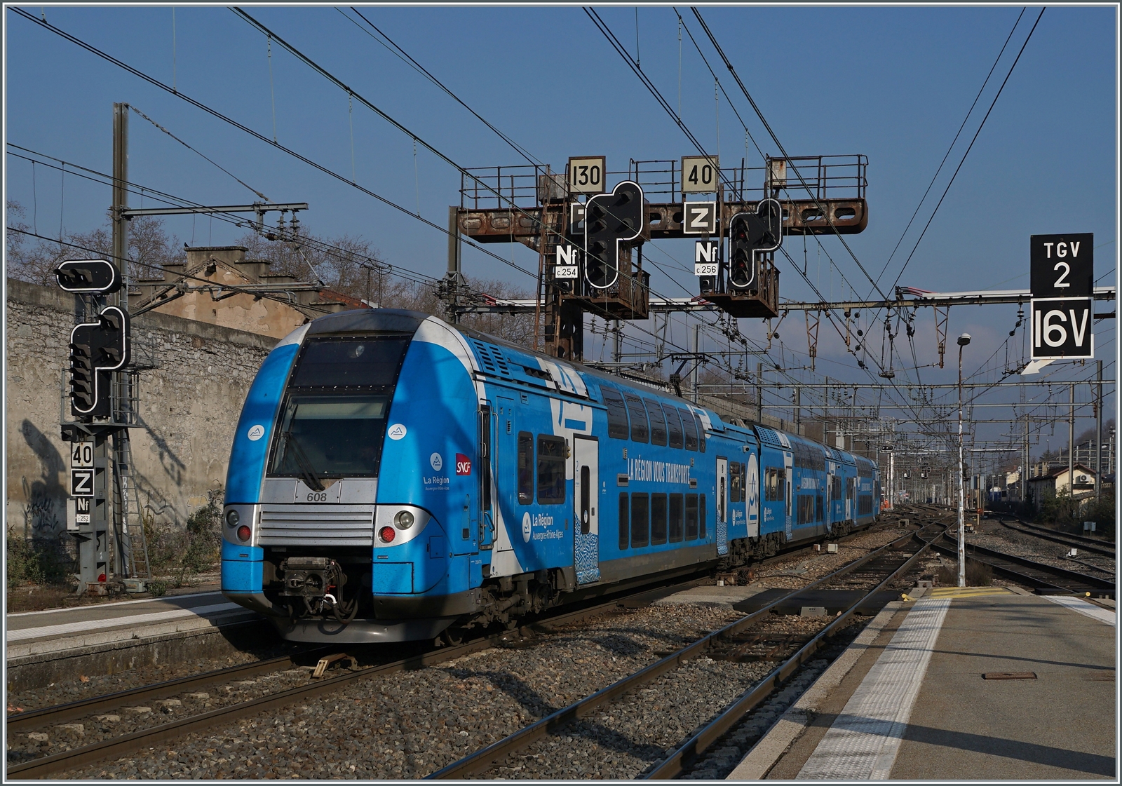 Unter einer mächtigen und für die SNCF so typischen Signalbrücke hindurch verlässt ein TER in Form des SNCF Z 24608  den Bahnhof von Chambéry Challes des Eaux.

22. März 2022