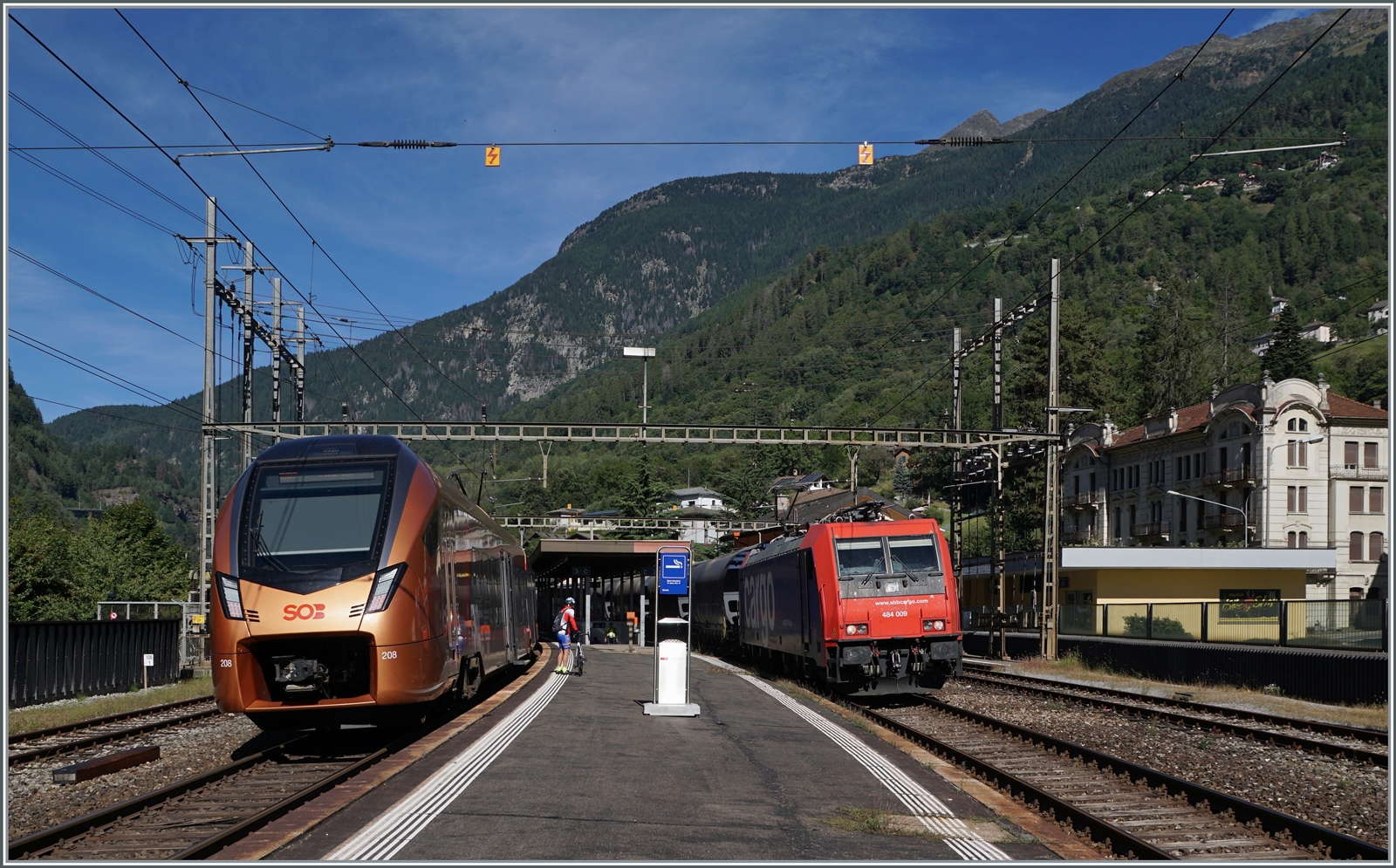 Während der SOB RABe 526 208  TRAVERSO  als RE 2120  Treno Gottardo  von Locarno nach Basel SBB unterwegs ist und in Faido hält, fährt die SBB Re 484 009 mit ihrem Güterzug nach Süden in Faido durch. 

4. September 2023