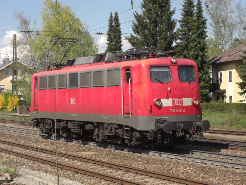 110 210-2 auf dem Weg Richtung Salzburg. Aufgenommen am 19. April 2009 bei der Ausfahrt aus dem Bahnhof von Prien am Chiemsee.