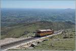 Das Bild zeigt einen der nahen Gipfelstation zustrebend Chemin de fer de la Rhune Zug, Dabei gleitet der Blick weit über das (französische*) Baskenland und links im Bild ist die Ausweichstation der Chemin de fer de la Rhune zu erkennen. 

 ...