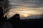Aus dem Sonnenuntergang heraus kam am 28.03.15 die Mühldorfer 245 013-8 mit ihrem Doppelstockzug zur Stadt am Inn des Weges. Das Bild entstand am Rande Poings.