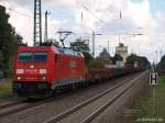 Mit einem langen Rungenwagen-Gterzug von Maschen durchfhrt 185 246-6 am 4.9.10 den Ort Tostedt auf dem Weg gen Bremen.