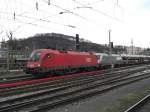 1016 043-0 und der  Siemens-Taurus  vor einem Gterzug im Salzburger  Hauptbahnhof.