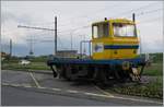 Ein Ding, wie ich es noch nie gesehen habe, welches aber wie eine Rangierlokomotive aussieht, aber neben den Schienen steht.