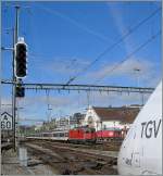 Whrend der TGV Lyria vorwitzig seine Nase ins Bild streckt, erreicht eine SBB Re 4/4 II mit EW I/II Wagen Lausanne.
