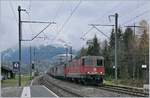Mit der SBB Re 420 338-6 an der Spitze fährt ein langer, von etlichen PS gezogener Güterzug durch den Bahnhof von Mülenen.