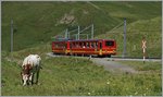 Ein klassischer Jungfraubahn Pendelzug hat die Kleine Scheidegg verlassen und fährt nun Bergwärts.